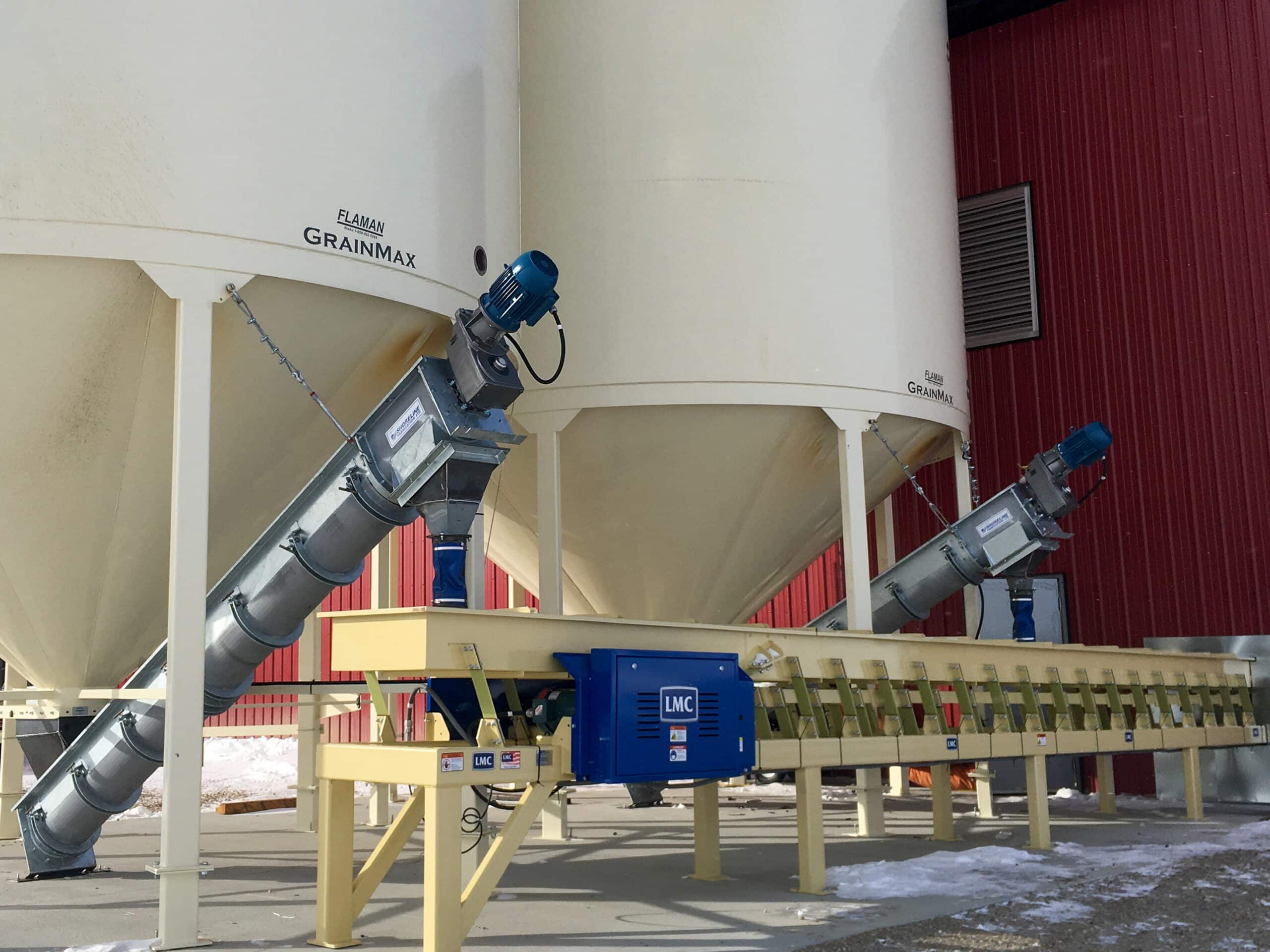 LMC vibratory conveyors installed under bins in a seed processing facility — Vistasort Canada