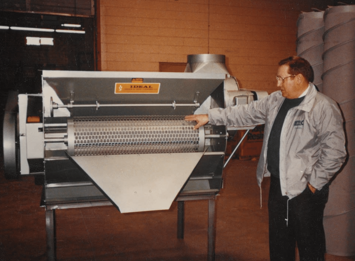 Vistasort — Bernie Chivilo inspecting an Ideal Grain & Seed Cleaner at a customer's warehouse, 1993