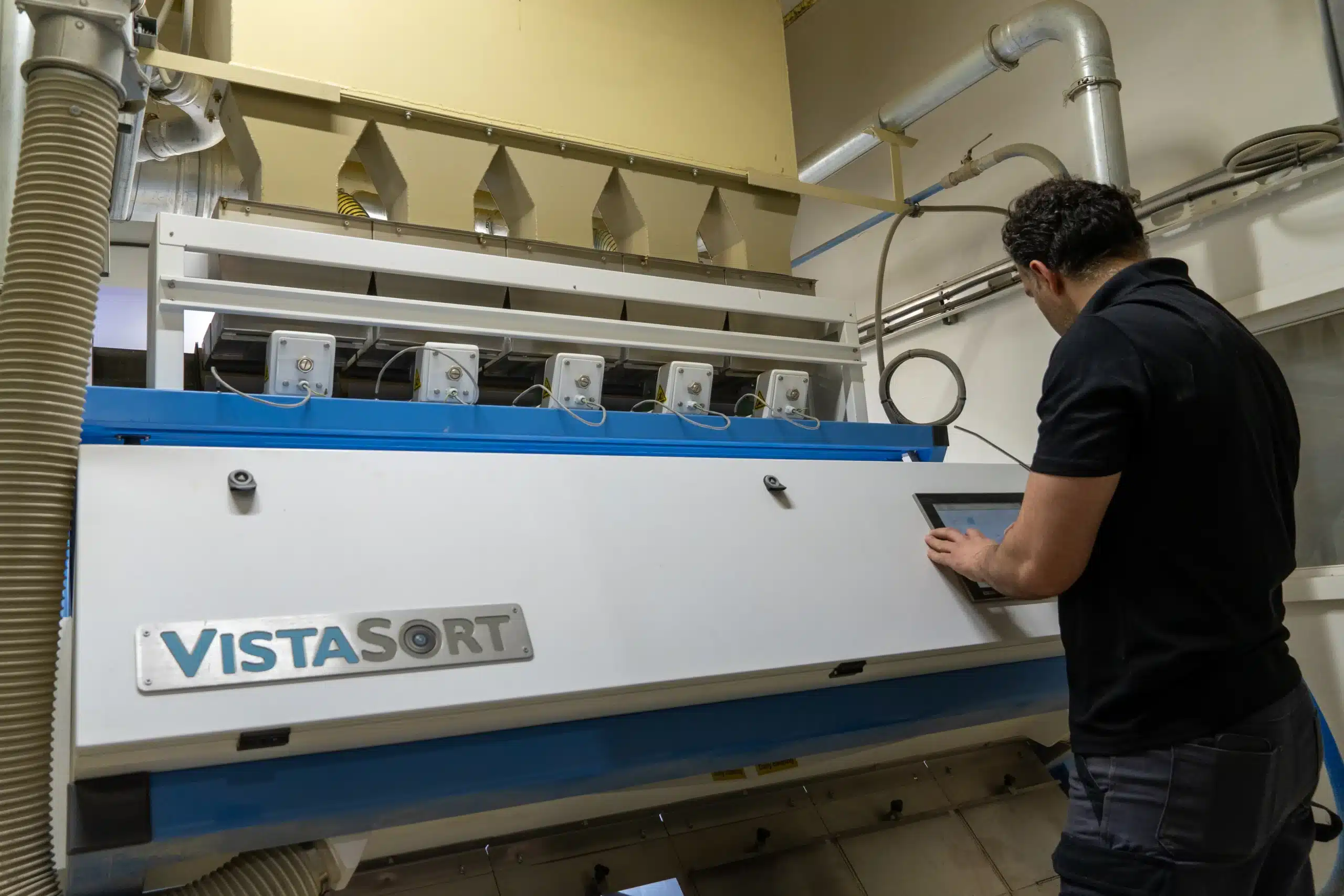 Vistasort technician servicing a VistaSort optical color sorter, Saskatoon